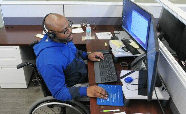 Handicapped man sitting at desk working