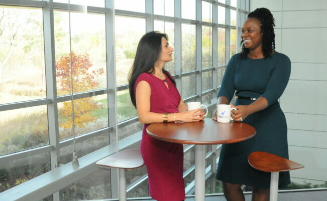 Two women standing in an office talking