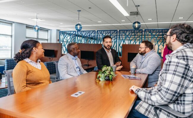 Group of people sitting at table in Wespath office talking
