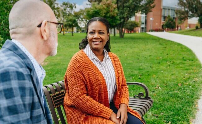 Woman and man sitting on bench outside
