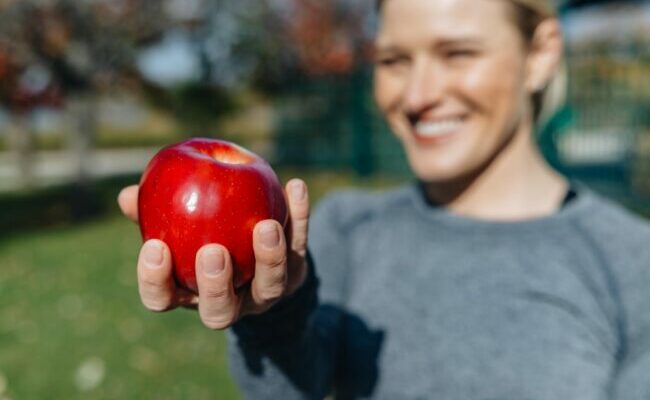Woman holding apple outside