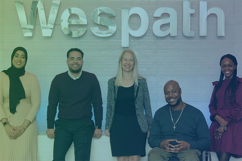 Five people standing in front of the Wespath logo