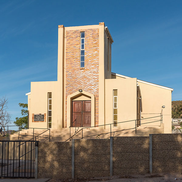 A light brown church with a fence.