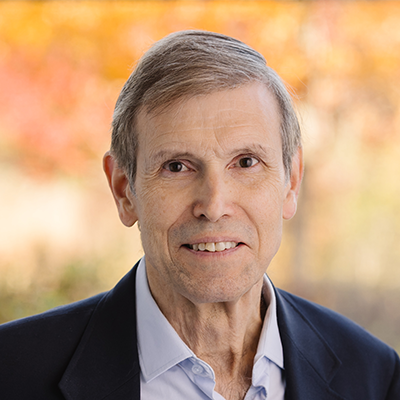 Portrait of Dale Jones smiling wearing a light collared shirt and black blazer.