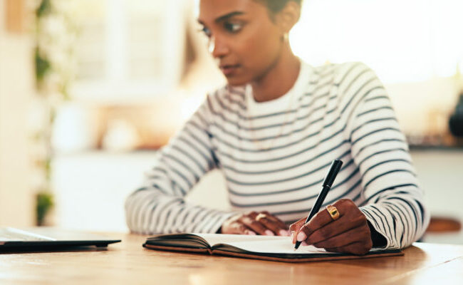 Woman studying with book and pen